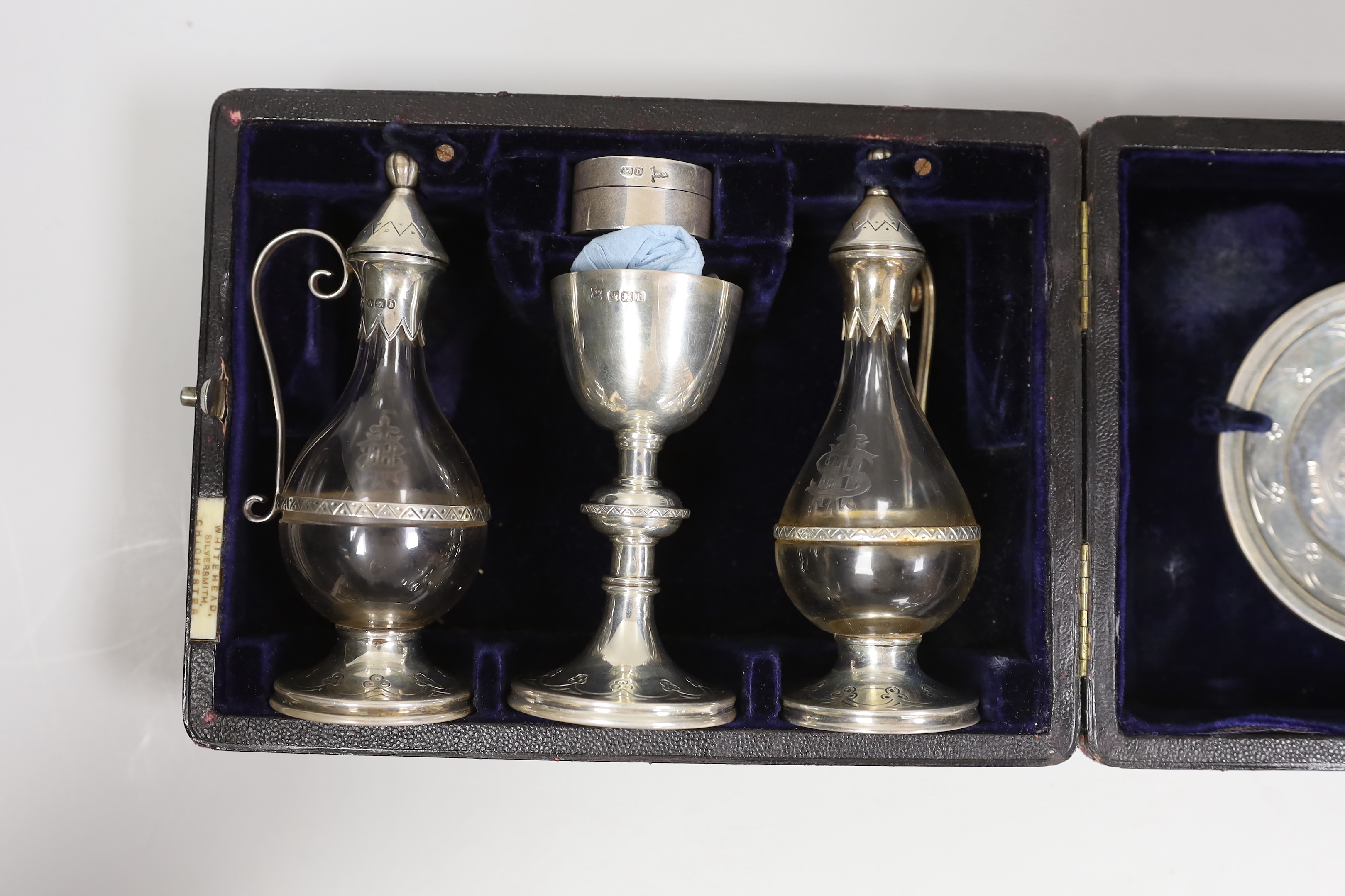 A cased late Victorian four piece silver communion set, Henry Wilkinson & Co Ltd, Sheffield, 1894, together with a matched wafer box and spoon, Walker & Hall, 1904/1906.